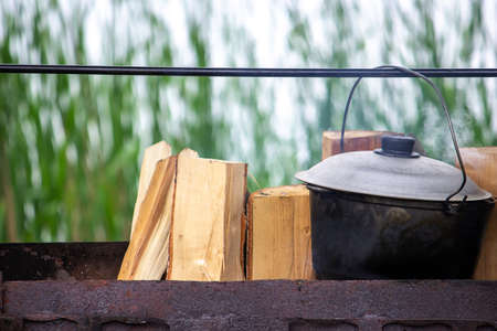 Cooking in a cast iron cauldron on a tripod over an open fire. Selective focusの写真素材