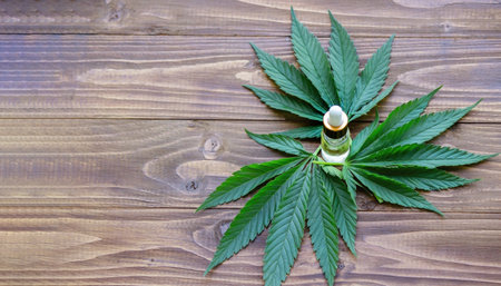 cannabis leaves on wood background with bottles, cannabis oil. Selective focusの写真素材