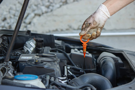 An auto mechanic changing oil pours oil into a car engine. Selective focus