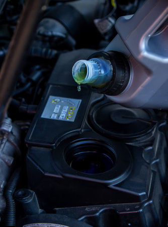 An auto mechanic changing oil pours oil into a car engine. Selective focusの写真素材
