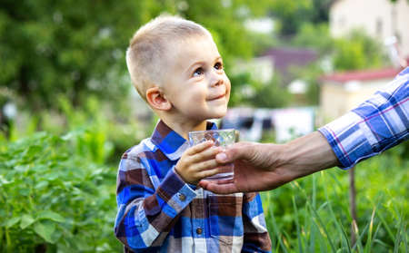 The child drinks clean water in nature. Selective focusの写真素材