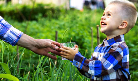 The child drinks clean water in nature. Selective focusの写真素材