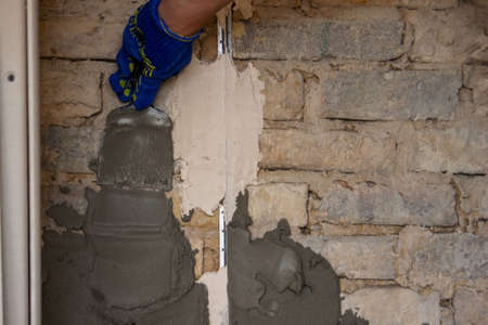 man plastering the wall. Construction, repairs in the house. Selective focusの写真素材