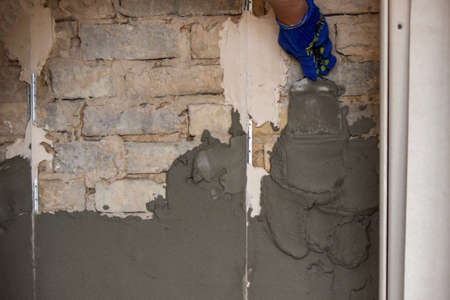 man plastering the wall. Construction, repairs in the house. Selective focusの写真素材