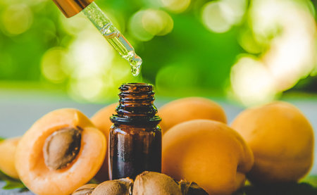 Apricot kernel oil in a small bottle. Selective focus. Nature.