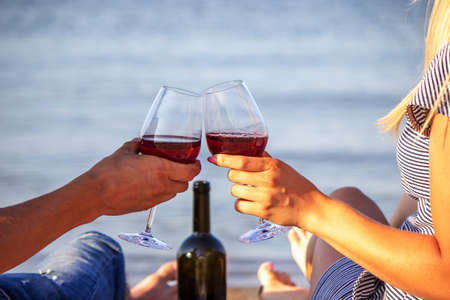 Romantic couple enjoying wine by the sea. Selective focusの写真素材