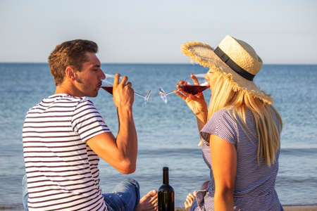 Romantic couple enjoying wine by the sea. Selective focusの写真素材