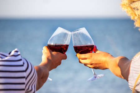 Romantic couple enjoying wine by the sea. Selective focusの写真素材