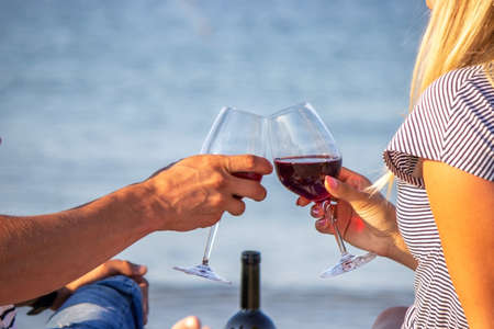 Romantic couple enjoying wine by the sea. Selective focusの写真素材