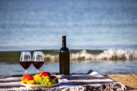 Picnic blanket, wine, fruit, beautiful sea beach Nature Selective focus