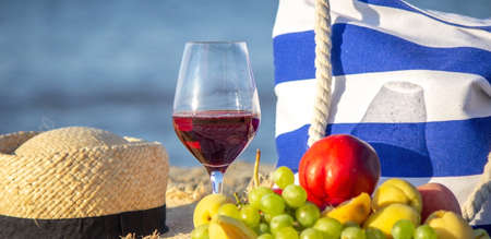 Picnic blanket, wine, fruit, beautiful sea beach Nature Selective focusの写真素材