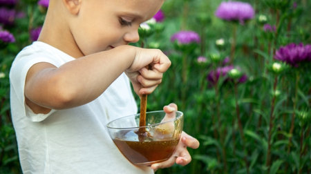 child eats honey in the garden. Selective focusの写真素材