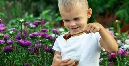 child eats honey in the garden. Selective focusの写真素材