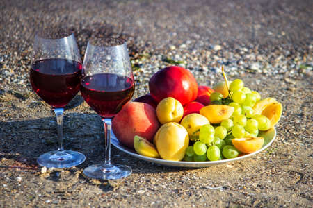 Picnic blanket, wine, fruit, beautiful sea beach Selective focusの写真素材