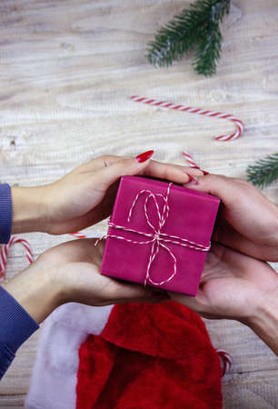 New Year's gifts in hands on a wooden background. Christmas selective focusの写真素材