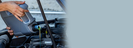 An auto mechanic changing oil pours oil into a car engine. Selective focus