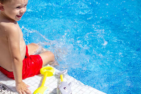 Happy child in the pool playing with a water gun. Recreationの写真素材