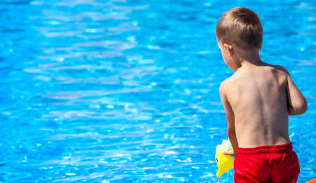 Happy child in the pool playing with a water gun. Recreationの写真素材
