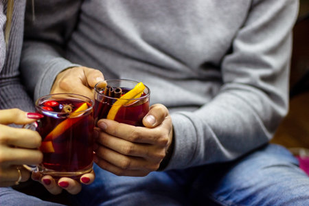 Hot mulled wine in male and female hands, spices. Sweet home conceptの写真素材