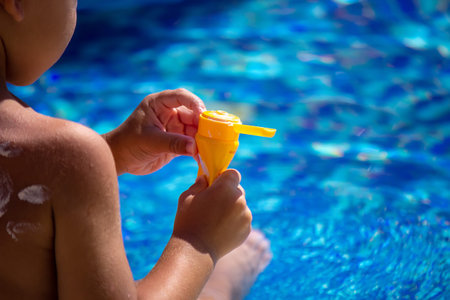 Mother puts cream on her son's back. Caring for baby skin. Sunscreens in the travel