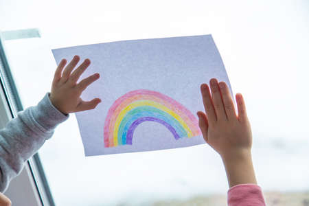 drawn rainbow on a sheet. Children hold a leaf with a rainbow near the window. selective focusの写真素材