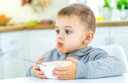 children in the kitchen at the table turning pasta. selective focusの写真素材