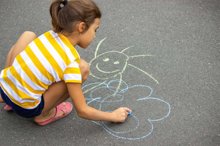the child draws with chalk on the pavement, the heart is the sun. Nature. selective focusの写真素材