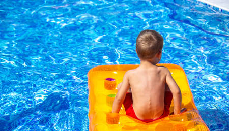 rest. The child floats on an inflatable mattress in the pool. selective focusの写真素材