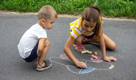 children draw on the pavement with chalk. very good weather. selective focusの写真素材