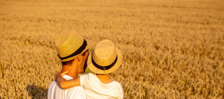 farmer and his son walking fields of wheat.selective focusの写真素材