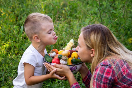 Child in the garden with vegetables in his hands. selective focus. nature.の写真素材