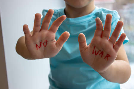 a little boy has an inscription on his palms no to war. selective focusの写真素材