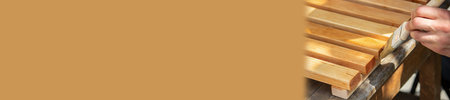 Painting wooden furniture with lacquer. a man hides a tree with varnish. selective focus