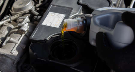 Refueling and pouring oil quality into the engine motor car Transmission and Maintenance Gear .Energy fuel concept. selective focusの写真素材