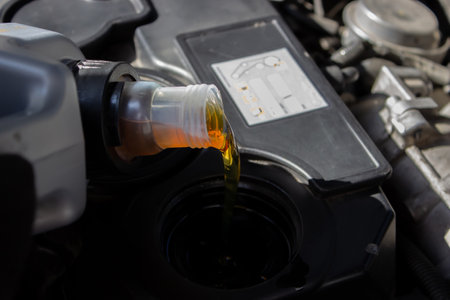 Refueling and pouring oil quality into the engine motor car Transmission and Maintenance Gear .Energy fuel concept. selective focusの写真素材
