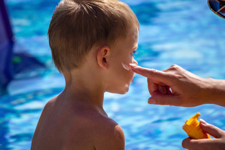 mother smears the child with sunscreen. selective focus