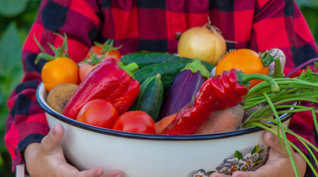 A child holds a harvest of vegetables in his hands. selective focus. nature.