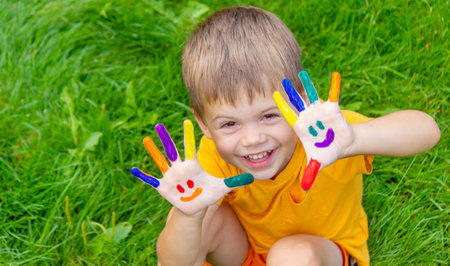 Children's hands in the colors of summer, a smile on the boy's palm. selective focusの写真素材