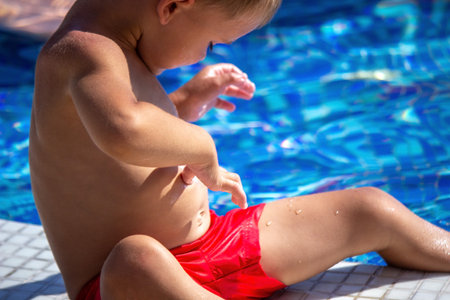 A child applying sunscreen to his stomach. selective focus.の写真素材