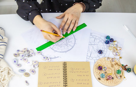 Woman astrologer draws a natal chart. selective focus. people.の写真素材