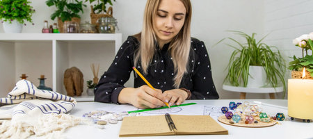Woman astrologer draws a natal chart. selective focus. people.の写真素材