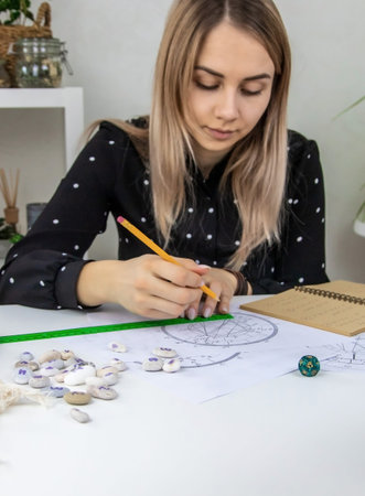 Woman astrologer draws a natal chart. selective focus. people.