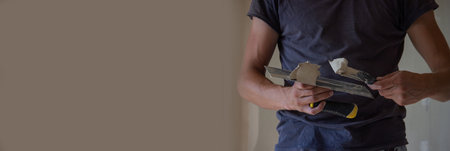 A man holds a spatula with putty in his hands. selective focus. constructionの写真素材