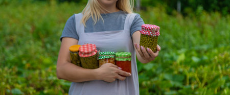 A woman preserves vegetables in jars. selective focus. food.の写真素材