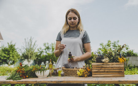 Woman with medicinal herbs and tinctures. selective focus. Nature.の写真素材