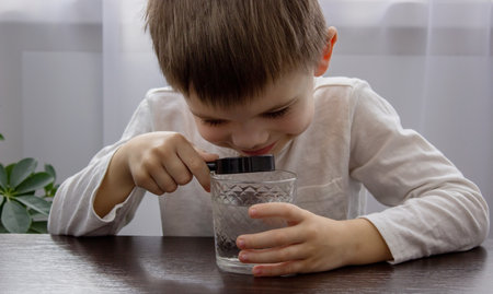 the child looks at the water through a magnifying glass. selective focus. Natureの写真素材