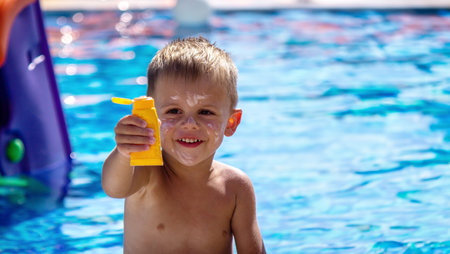 a boy in the pool smeared with suntan cream. selective focusの写真素材