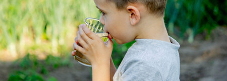 Cute little boy drinks water from a glass. selective focus