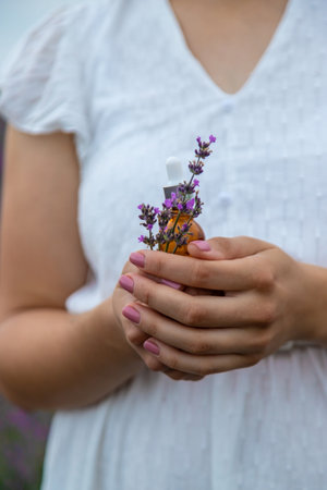 Woman holding bottle with natural essential oil in lavender field. selective focus. Natureの写真素材