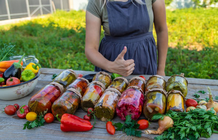 A woman preserves vegetables in jars. selective focus. food.の写真素材